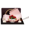 Bild von Tischdekoration mit rosa Decke, Kerzenhalter und Blumenschale