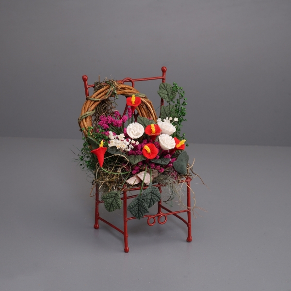 Picture of Red Metal chair decorated with many flowers