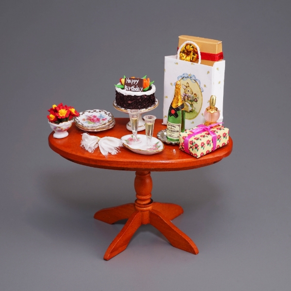 Bild von Geburtstagstisch mit Geschenken, Torte und Sekt